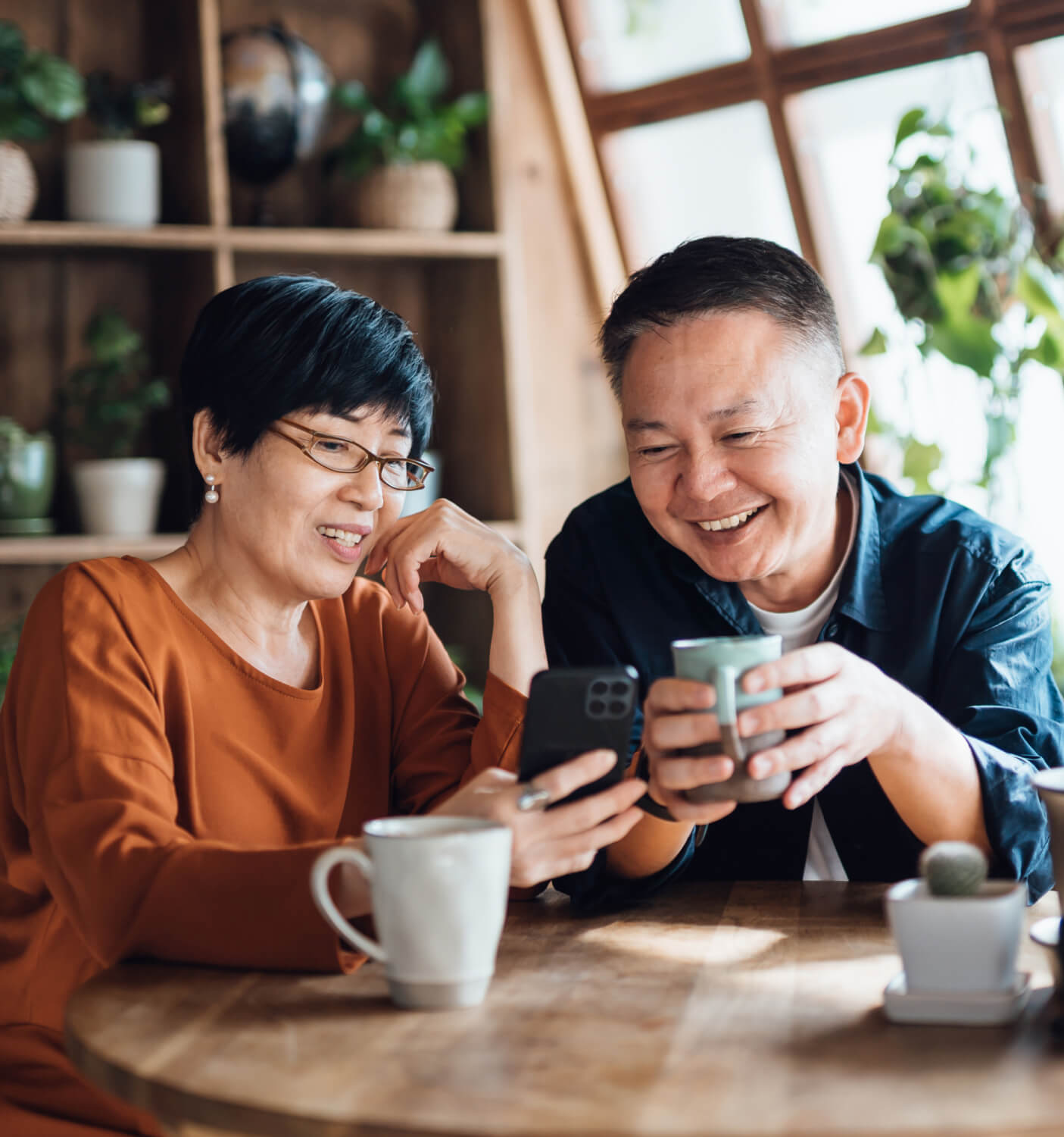 Man and woman drinking coffee and looking at phone